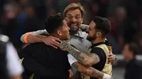 Pelatih Jurgen Klopp memeluk Roberto Firmino dan Danny Ings usai pertandingan semifinal Liga Champions di Stadion Olimpiade, Roma (2/5). Liverpool takluk 4-2 atas Roma di leg kedua dan melaju ke final usai menang agregat 7-6. (AFP Photo/Paul Ellis)