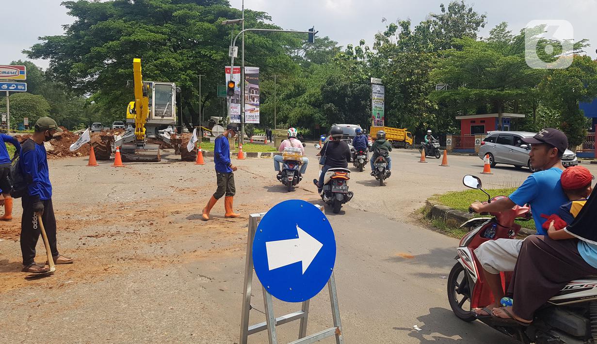 Pengendara melintas dekat jalan ambles di ruas Jalan Boulevard, Grand Depok City (GDC), Kota Depok, Jawa Barat, Selasa (13/4/2021). Sejumlah alat berat dikerahkan untuk mengangkut tanah yang longsor. (Liputan6.com/Herman Zakharia)