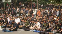 Sejumlah mahasiswa melaksanakan salat berjamaah di Jalan Diponegoro, Kota Bandung, di sela-sela unjuk rasa menolak Revisi UU KPK dan RUU KUHP. (Liputan6.com/Huyogo Simbolon)