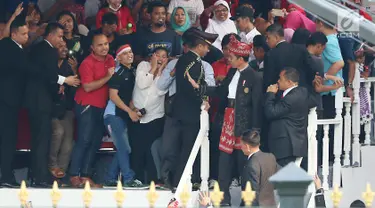 Presiden Joko Widodo atau Jokowi menyempatkan diri menyalami tamu undangan di halaman Istana Merdeka, Jakarta, Kamis (17/8). Hal ini disambut meriah para tamu yang kemudian bangkit berebut untuk berfoto bersama Jokowi. (Liputan6.com/Angga Yuniar)