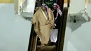 Raja Arab Saudi, Salman bin Abdulaziz Al Saud dibantu pengawalnya menuruni tangga eskalator saat tiba di Vnukovo International Airport, Rusia, 4 Oktober 2017. Ketika sang raja baru turun setengah tangga medadak eskalator emas itu mati (AP/Ivan Sekretarev)