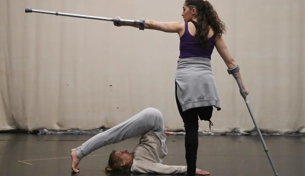 Seorang wanita dari Candoco Dance Company menggunakan tongkat saat latihan jelang pertunjukan di London utara, Inggris (13/4). (AFP Photo/Daniel Leal Olivas)