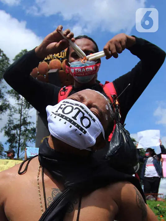 Seorang jurnalis melakukan aksi teatrikal saat aksi solidaritas di kawasan Tugu Adipura, Kota Tangerang, Rabu (31/3/2021). Mereka menuntut pihak berwenang mengusut tuntas oknum pelaku kekerasan terhadap wartawan Tempo, Nurhadi dan kasus kekerasan jurnalis lainnya. (Liputan6.com/Angga Yuniar)