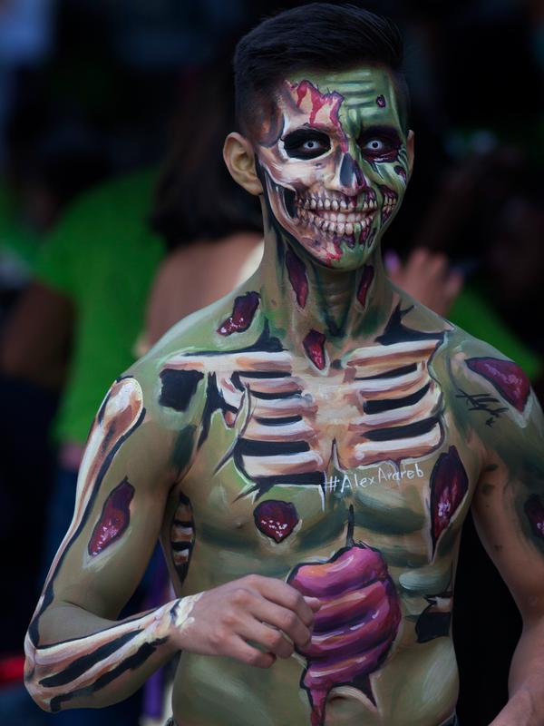 Seorang pria berpartisipasi dalam Zombie Walk di Mexico City, Minggu (11/11). Dalam acara tahunan itu ratusan orang dengan penampilan yang seram serta mengenakan pakaian compang-camping berkumpul di pusat bersejarah ibu kota Meksiko. (AP/Claudio Cruz)