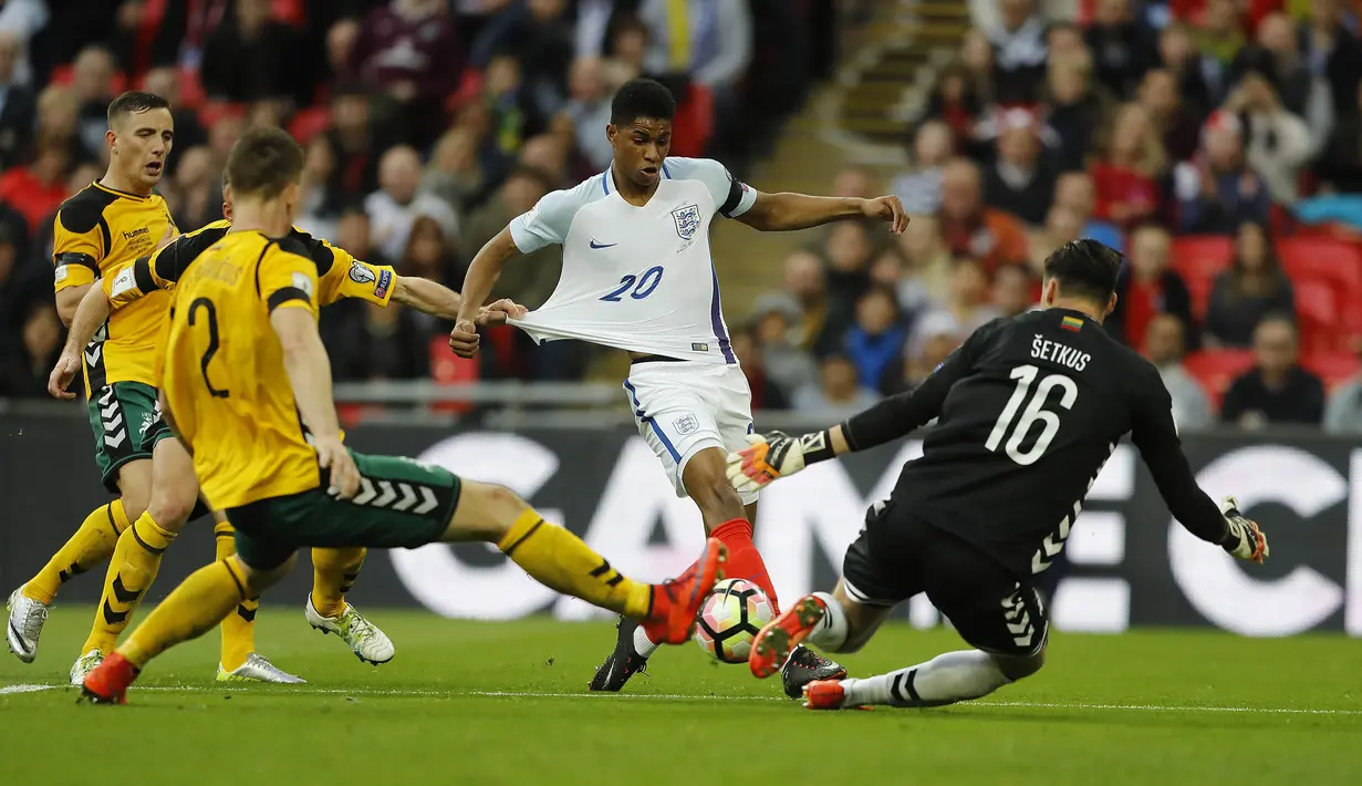 Gelandang Inggris, Marcus Rashford, berusaha melewati kiper Lithuania, Ernestas Setkus. Kemenangan ini membuat Inggris kokoh di puncak klasemen grup F dengan koleksi 13 poin dari lima laga. (AP/Frank Augstein)