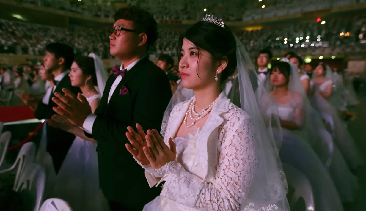 Ekspresi salah satu pasangan saat mengikuti pernikahan massal di Pusat Perdamaian Cheong Shim di Gapyeong, Korea Selatan, (7/9). Sebanyak 4.000 pasangan Korea Selatan dan asing ikut serta dalam acara ini. (AP Photo / Ahn Young-joon)