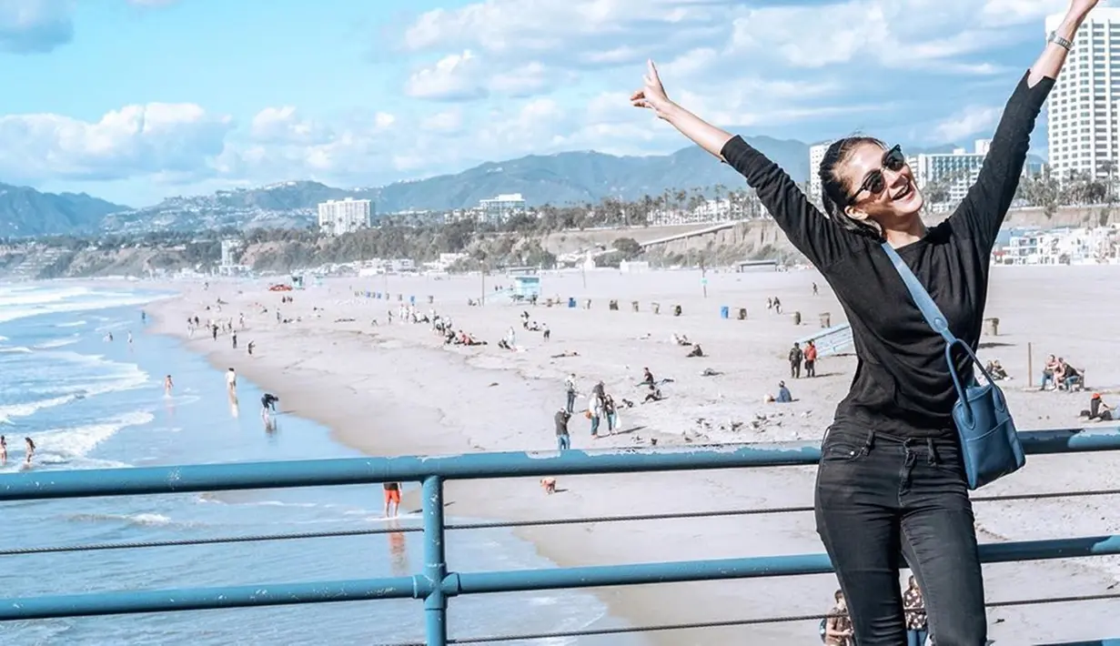 Paula sering tampil menggunakan busana berwarna hitam saat liburan. Saat berlibur di Pantai Santa Monica, ia tampak bahagia menggunakan baju dan celana jeans berwarna hitam ditemani dengan tas berwarna biru. (Liputan6.com/IG/@paula_verhoeven)