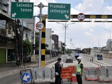 Petugas keamanan berjaga di depan pintu masuk Underpass Matraman, Jakarta, Minggu (1/4). Uji coba Underpass Matraman yang rencananya dimulai pada hari ini batal dilakukan karena masih dalam pembahasan rekayasa lalu lintas. (Merdeka.com/Iqbal S Nugroho)