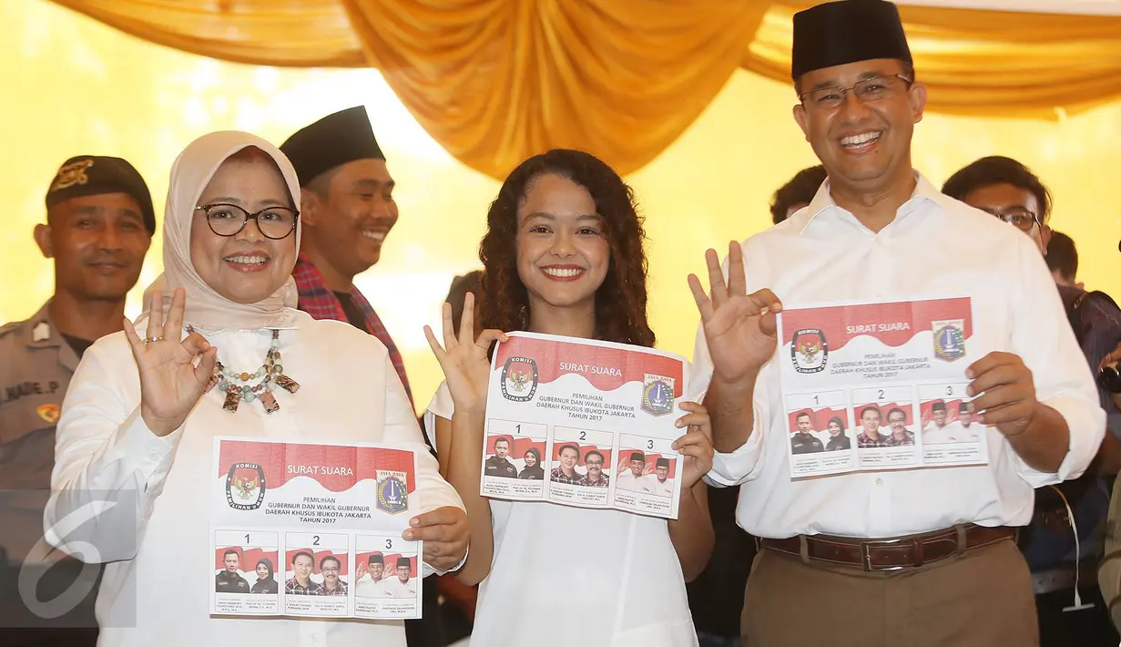 Calon Gubernur DKI Jakarta Anies Baswedan bersama istri, Fery Farhati, dan anak perempuannya menunjukkan surat suara sambil berpose salam 3 jari sebelum mencoblos di TPS 028 Cilandak Barat, Jakarta Selatan, Rabu (15/2). (Liputan6.com/Immanuel Antonius)