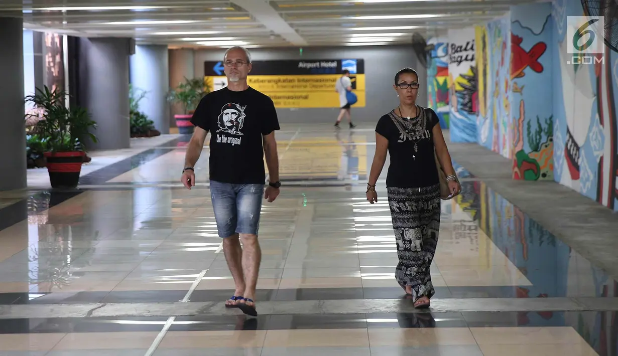 Calon penumpang berjalan di area terminal International Bandara I Gusti Ngurah Rai, Bali, Kamis (30/11). Bandara tersebut kembali beroperasi terhitung pukul 15.00 WITA, Rabu (29/11). (Liputan6.com/Immanuel Antonius)
