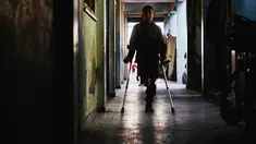 Rateb Mahmoud Qaliq berjalan menggunakan kruk di sepanjang lorong sekolah UNRWA yang telah menjadi tempat penampungan bagi pengungsi Palestina di Deir al-Balah, di Jalur Gaza tengah, pada 3 Desember 2025. Rateb Mahmoud Qaliq merupakan seorang anak laki-laki Palestina berusia sembilan tahun dari Jalur Gaza. (Bashar Taleb/AFP)