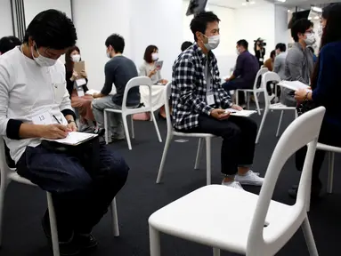 Peserta pria dan wanita menggunakan masker mengikuti layanan kencan di Tokyo, Jepang, (16/10). Dibuatnya acara Layanan kencan yang Sedang Marak di Jepang ini diakibatkan menurunnya tingkat pernikahan yang mencapai 50 Persen. (REUTERS/Kim Kyung-Hoon)