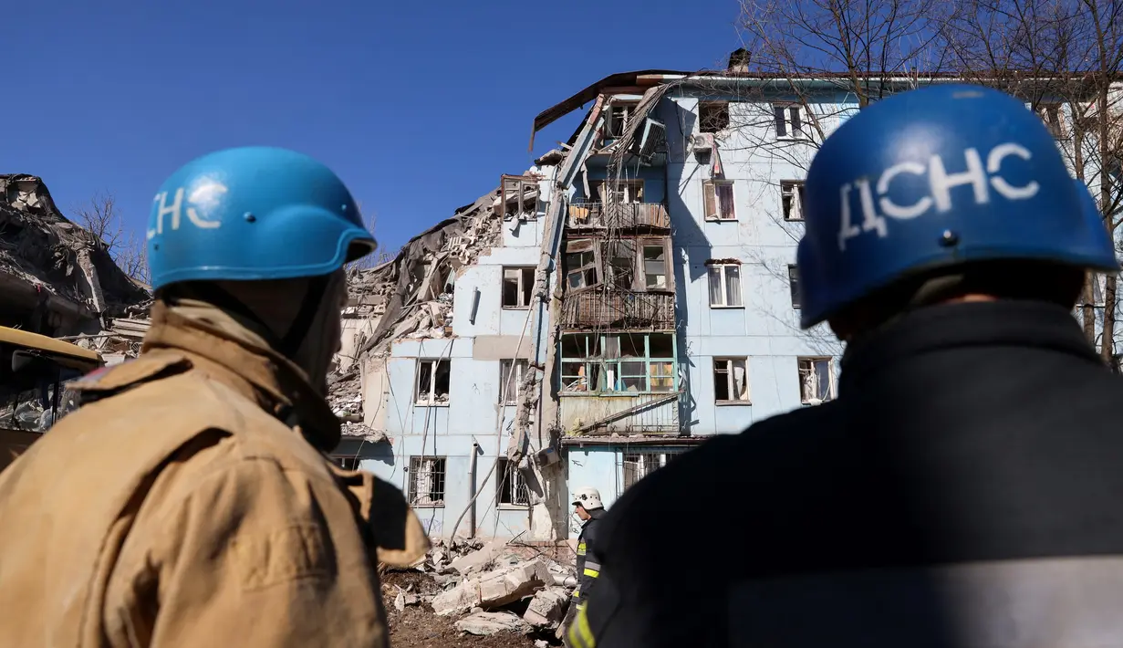 Tim penyelamat bekerja di gedung tempat tinggal berlantai lima yang hancur setelah serangan rudal di tengah invasi Rusia ke Ukraina di Zaporizhzhia pada 2 Maret 2023. Di antara mereka yang selamat adalah seorang pria berusia 30 tahun yang menurut petugas penyelamat terjebak di bawah lempeng beton akibat serangan rudal. (AFP/Katerina Klochko)