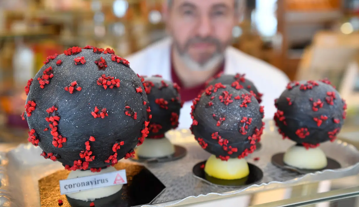 Pembuat cokelat, Jean-François Pre menunjukkan telur paskah berbentuk seperti Virus Corona di tokonya di Landivisiau, Prancis, 7 Maret 2020. Cokelat ini terbuat dari cokelat putih yang diberikan pewarna hitam serta dipadukan dengan kacang almond yang diwarnai merah. (Damien MEYER/AFP)