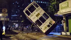 Sebuah trem double-decker diangkat menggunakan crane setelah terbalik di jalan utama di Hong Kong, Kamis (6/4). Kecelakaan yang terjadi tengah malam waktu setempat itu mengakibatkan 11 orang mengalami luka-luka. (ANTHONY WALLACE / AFP)