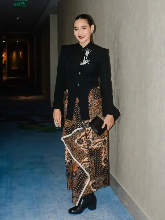 Ine Febriyanti juga tampil dengan atasan bersiluet kebaya janggan berwarna hitam, yang juga rancangan dari Wilsen Willim. Top yang dikenakannya ini memiliki detail kancing di bagian tengah dan potongan bagian bawah yang unik. [Foto: Instagram/ipmi.ind]