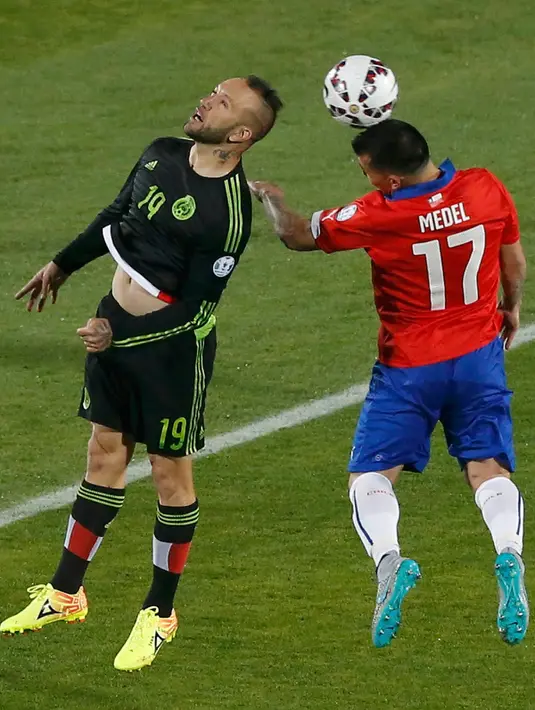 Penyerang Meksiko, Vicente Vuoso berebut bola udara dengan bek Chile Gary Medel saat pertandingan Copa America 2015 di National Stadium, Santiago, Chile, (16/6/2015). Chile bermain imbang 3-3 dengan Meksiko. (REUTERS/Carlos Garcia Rawlins)