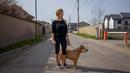 Silvia Rad (34) berpose dengan anjingnya Sa'id (12) saat perjalanan di Bucharest (28/3/2020). Undang-undang militer, yang disahkan pemerintah Rumania untuk mengurangi penyebaran virus corona, menyatakan berjalan bersama anjing adalah salah satu  kegiatan yang masih diizinkan. (AFP/Andrei Pungovschi)