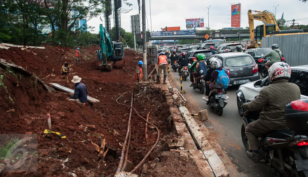 Pengendara melintas di dekat pekerja yang sedang mengerjakan proyek underpass di Jalan RA Kartini, Metro Pondok, Lebak Bulus, Jakarta, Rabu (22/3). Pembangunan underpass ini untuk mengurai kemacetan di perempatan Lebak Bulus. (Liputan6.com/Gempur M Surya)