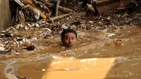 Warga nekat membuka aliran sungai Ciliwung yang terhambat akibat tumpukan sampah di kolong jembatan Rawajati, Kalibata, Jakarta, Senin (16/11/2015). Sampah yang didominasi batang bambu akibat hujan deras, Minggu (15/11). (Liputan6.com/Helmi Fithriansyah)