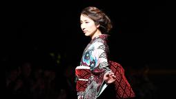 Seorang model berpose dalam balutan kimono rancangan desainer Jepang, Jotaro Saito untuk koleksi Fall Winter 2019/2020 pada Tokyo Fashion Week di Tokyo, Rabu (20/3/2019). (Photo by Toshifumi KITAMURA / AFP)