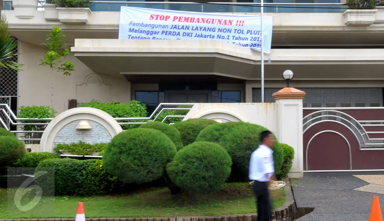 Sebuah spanduk penolakan terpasang di depan rumah warga di kawasan perumahan Pluit, Jakarta, Kamis (17/12). Warga Pluit menolak rencana pembangunan jalan layang non tol yang masuk ke pemukiman mereka. (Liputan6.com/Faisal R Syam)