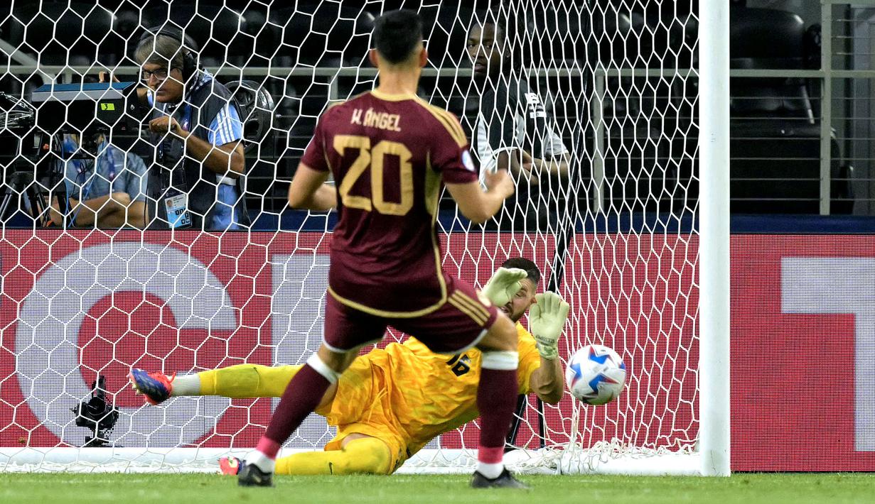 Kiper Kanada, Maxime Crepeau menggagalkan tendangan pemain Venezuela, Wilker Angel pada babak adu penalti saat laga perempat final Copa America 2024 di AT&T Stadium, Arlington, Texas, Sabtu (06/07/2024) WIB. (AFP/Juan Mabromata)