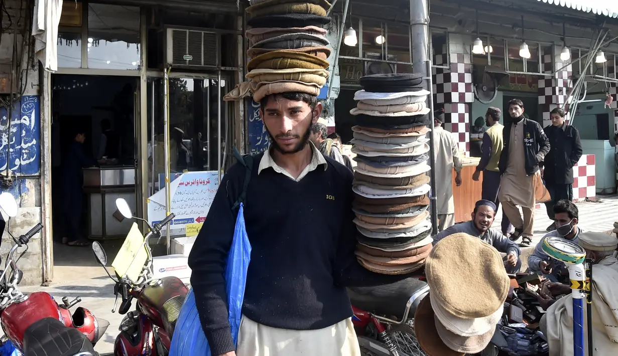 Seorang penjual menjajakan topi tradisional di sebuah jalan di Peshawar, Pakistan barat laut, pada 28 Desember 2020. Topi tradisional yang terbuat dari bahan wol ini sangat populer di kalangan warga Pakistan selama musim dingin. (Xinhua/Saeed Ahmad)