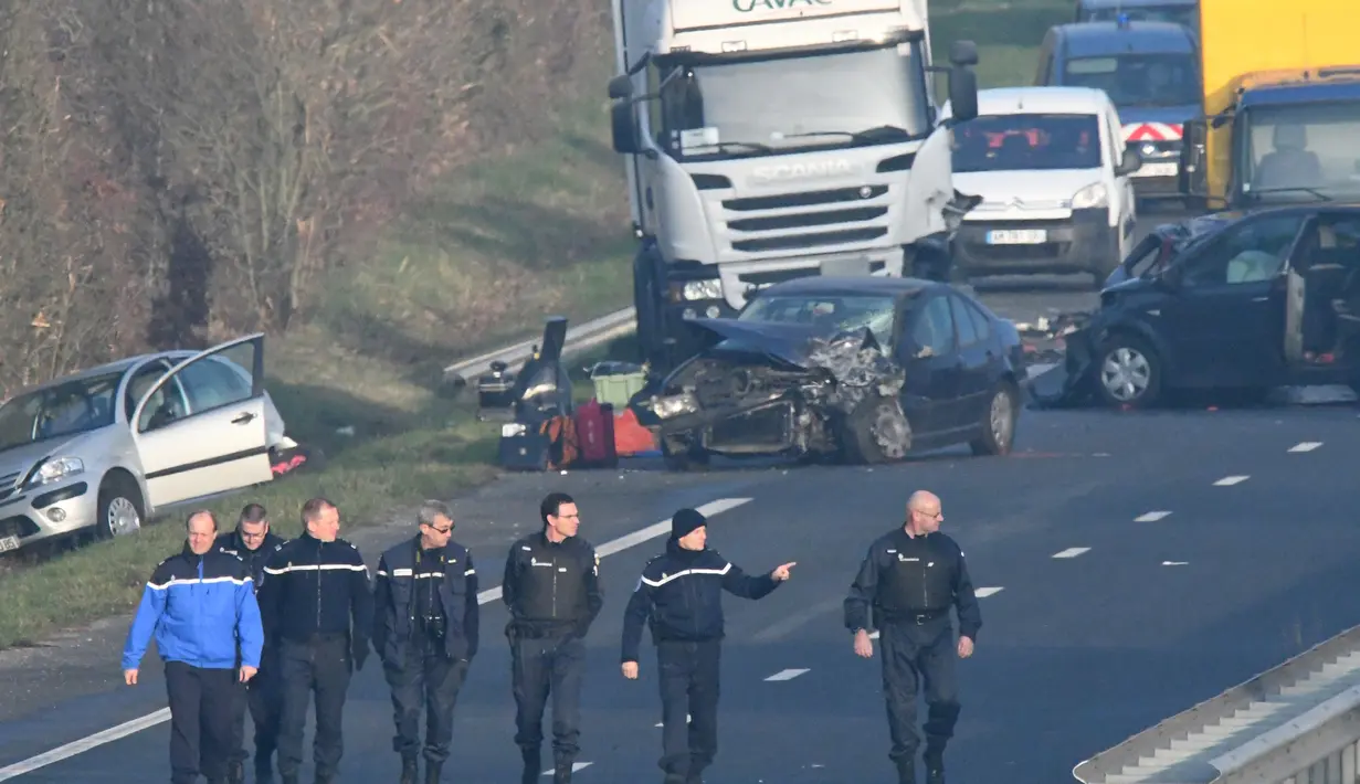 Aparat kepolisian tiba di lokasi tabrakan beruntun di Jalan D12 antara La Roche-sur-Yon dan Les Sables d'Olonne, sebelah barat Prancis, Selasa (20/12). Kecelakaan yang melibatkan sekitar 50 kendaraan itu menewaskan 5 orang. (JEAN-FRANCOIS MONIER/AFP)