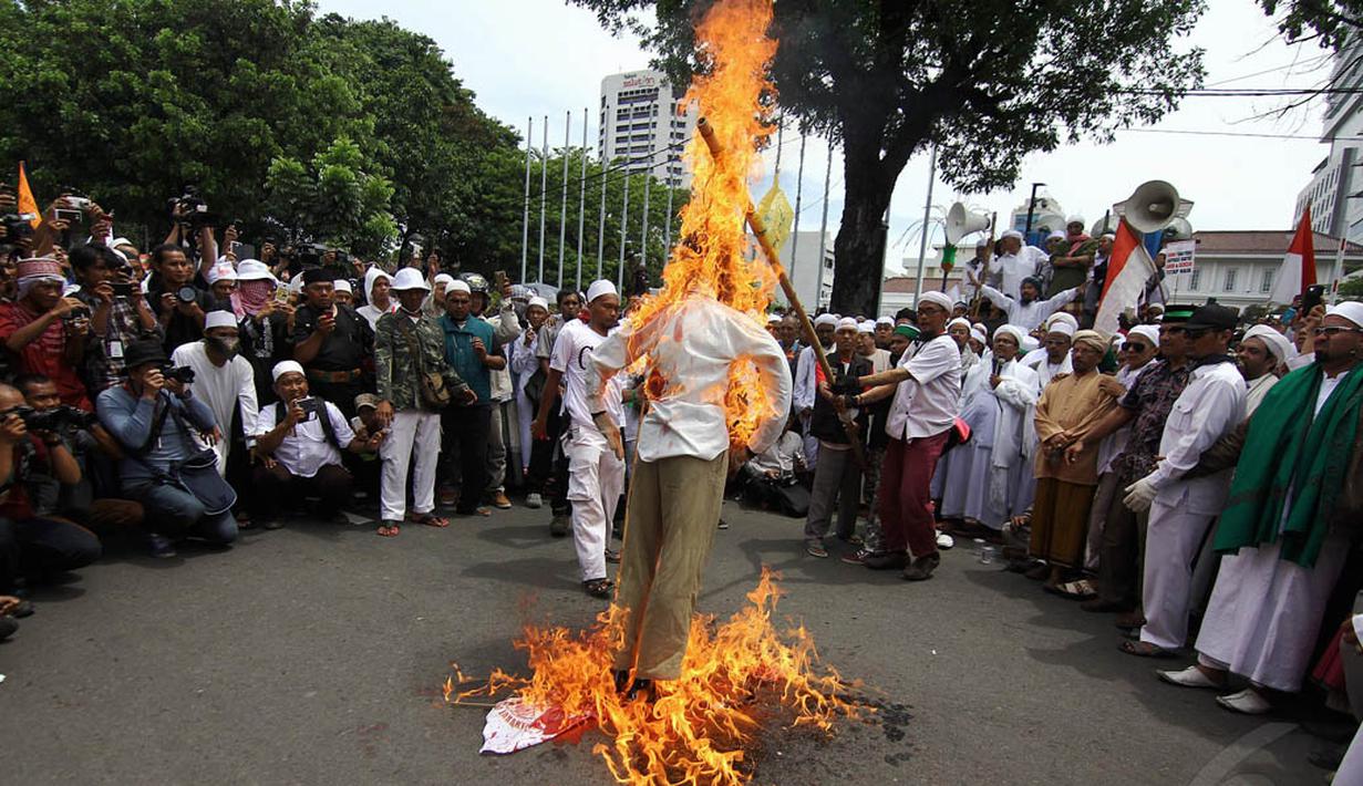 Dalam aksinya, massa melakukan pembakaran boneka di depan Balaikota, Jakarta, Senin (1/12/2014). (Liputan6.com/Faizal Fanani) 
