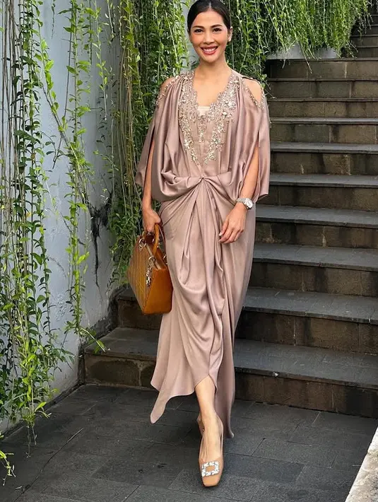 Nadia Mulya mengenakan kaftan warna coklat shimmer yang memiliki aksen beads di bagian kerah model v neck. Kaftan tersebut semakin menarik dengan model cut out di pundak. [@nadiamulya]