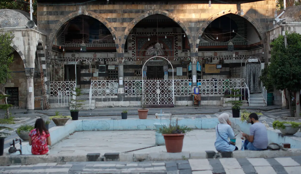 Warga Suriah bermukim di kompleks Takiyya di kota tua Damaskus, Suriah, (18/7). Kompleks Takiyya adalah bangunan kuno dengan halaman lanskap yang dibangun di tepi Sungai Barada. (AP Photo / Hassan Ammar)
