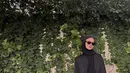 Tampil serba hitam, Paula padukan kemeja lengan gelembung, celana hijab, dengan kerudung lilit. Ditutup dengan kacamata hitam, loafers dan tas Hermes [@paula_verhoeven]