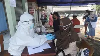 Suasana tes swab Covid-19 kepada para pedagang  di Pasar Sayur Cipulir, Jakarta Selatan, Kamis (25/6/2020). Kegiatan yang dilakukan kepada puluhan pedagang dan warga seputar pasar ini dalam rangka memutus mata rantai penyebaran penyakit corona. (merdeka.com/Arie Basuki)