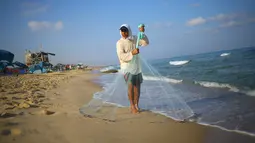 Nelayan Palestina, Jihad al-Soltan mencari ikan dengan melempar jala di pantai kawasan Beit Lahia, Jalur Gaza, Selasa (22/8). Soltan menemukan botol surat yang dihanyutkan pasangan Inggris yang tengah berlibur di Pulau Rhodes, Yunani. (MOHAMMED ABED/AFP)