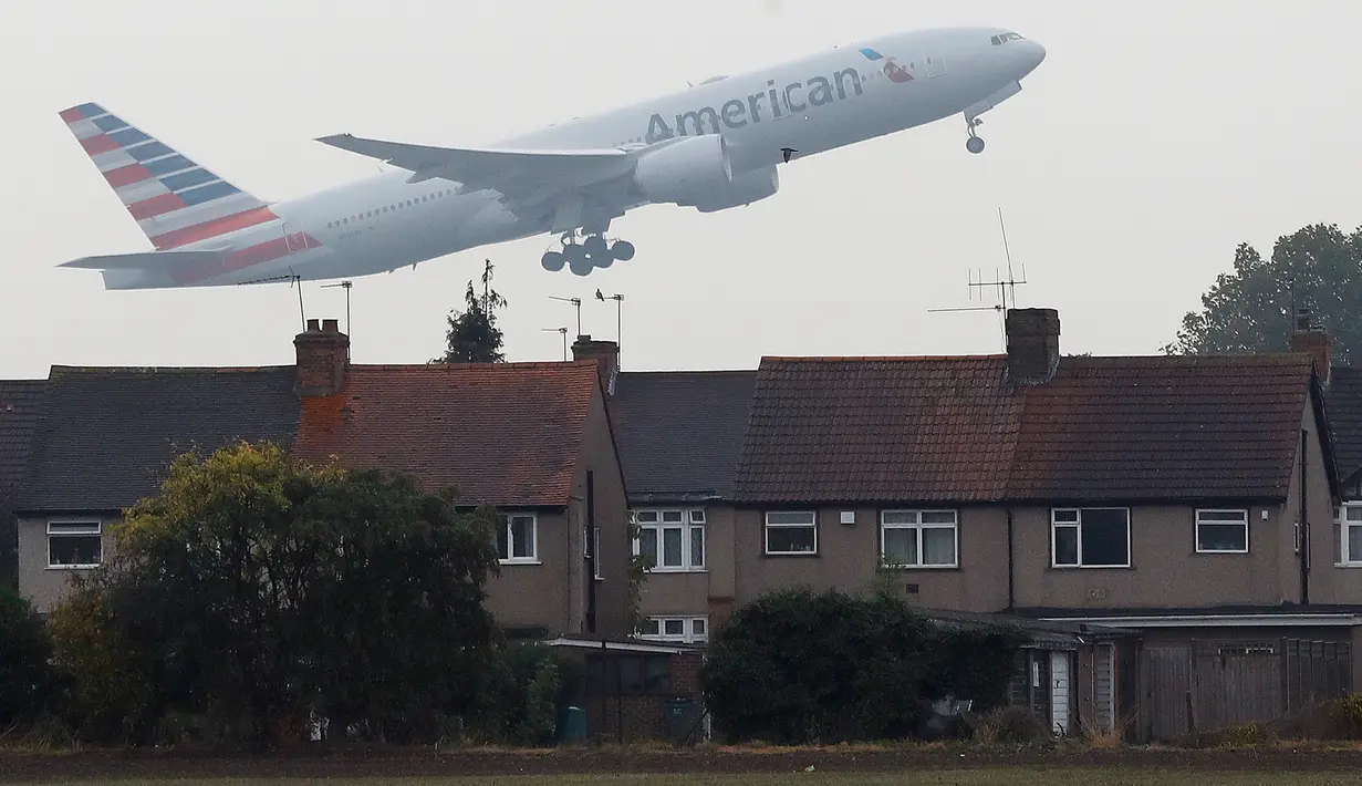 Pesawat terbang rendah dekat atap rumah saat lepas landas di Bandara Heathrow, London, 25 Oktober 2016. Perumahan yang terletak di Myrtle Avenue itu hanya sekitar 91 meter dari landasan Bandara Heathrow. (AP Photo / Frank Augstein)