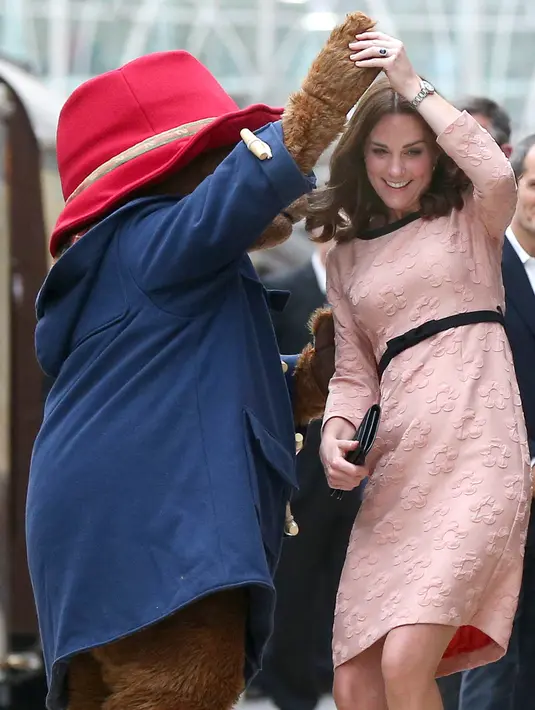 Kate Middleton asyik berdansa dengan seorang aktor yang mengenakan kostum Paddington di stasiun kereta Paddington, London, Senin (16/10). Duchess of Cambridge itu tampak menikmati momen dansa dengan Beruang Paddington. (Chris J Ratcliffe/AFP)