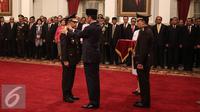 Presiden Jokowi memasang tanda pangkat kepada Kapolri M Tito Karnavian di Istana Negara, Jakarta, Rabu (13/7). Tito Karnavian dilantik dengan Keputusan Presiden tentang pengangkatan Kapolri Nomor 48/Polri/Tahun 2016. (Liputan6.com/Faizal Fanani)