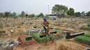 Seorang pekerja menyiram makam di TPU Karet Bivak, Jakarta, Rabu (7/10/2015).  Pengamat Tata Kota dari Universitas Trisakti Nirwono Yoga memprediksi DKI Jakarta akan mengalami krisis lahan makam pada 2017. (Liputan6.com/Gempur M Surya)