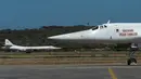 Dua pesawat pengebom jarak jauh jenis TU-160 ketika mendarat di Bandara Internasional Simón Bolívar, dekat Caracas, Senin (10/12). Rusia mengerahkan empat pesawat militer ke Venezuela untuk mengikuti latihan gabungan kedua negara. (Federico PARRA / AFP)