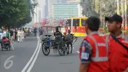Delman  melintasi Kawasan Bundaran HI ketika pelaksanaan Car Free Day di Jakarta, (26/6). Pelarangan itu untuk menegakkan aturan pemprov DKI Jakarta yang melarang operasional delman melintasi sejumlah protokol di Jakarta. (Liputan6.com/Gempur M Surya)