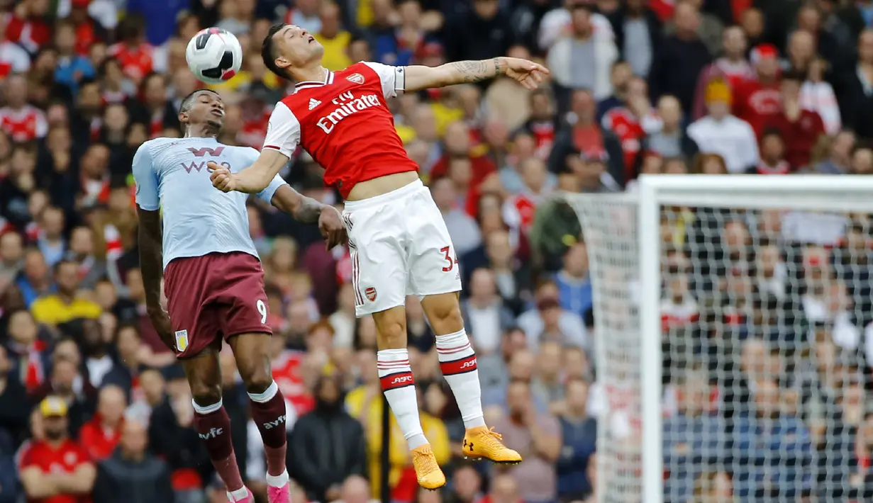 Striker Aston Villa, Wesley (kiri) berebut bola udara dengan gelandang Arsenal, Granit Xhaka selama pertandingan lanjutan Liga Inggris di Stadion Emirates, London (22/9/2019). Arsenal menang tipis atas Aston Villa 3-2. (AFP Photo/Tolga Akmen)