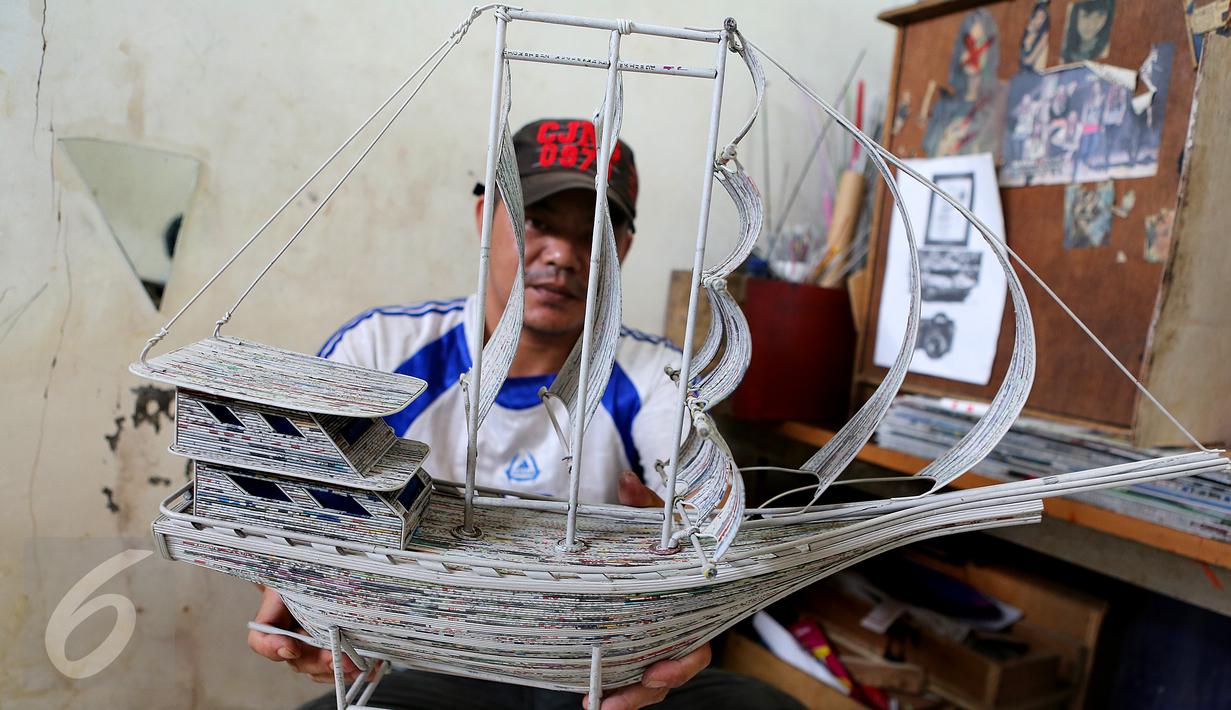 Seorang warga binaan menunjukan kapal pinishi yang terbuat dari lintingan koran di Lapas Kelas 1 Tangerang, Kota Tangerang.(29/10). Bahan yang dipergunakan yaitu koran bekas, lem kertas, dan kayu atau papan pendukung. (Liputan6.com/Fery Pradolo)