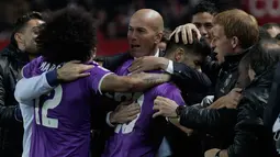 Zinedine Zidane berpelukan dengan pemainnya usai memastikan lolos ke perempat final Copa del Rey setelah menang agregat 6-3 atas Sevilla, Spanyol, Kamis (12 /1).  (AP Photo/ Angel Fernandez)