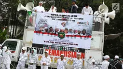 Massa Forum Umat Islam berorasi saat mengikuti kegiatan 'Apel Siaga Umat untuk Pemilu Bersih, Jujur, dan Adil' di depan Kantor KPU, Jakarta, Minggu (31/3). Dalam aksinya, massa menolak segala bentuk kecurangan dalam Pemilu yang akan berlangsung 17 April mendatang. (Liputan6.com/Immanuel Antonius)