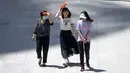 <p>Para wanita melindungi diri dari sinar matahari saat mereka berjalan melintasi alun-alun di kompleks perbelanjaan dan perkantoran pada hari yang panas di luar musimnya di Beijing, China, Rabu (7/6/2023). Suhu tinggi di Ibu Kota China itu diperkirakan sekitar 100 derajat Fahrenheit (38 derajat Celcius) pada hari Selasa. (AP Photo/Mark Schiefelbein)</p>