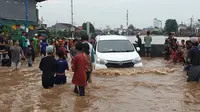 Saat banjir meninggi, warga Kampung Pulo mempercepat evakuasi diri dan barang berharga. (Foto: Liputan6/Nanda Perdana Putra)