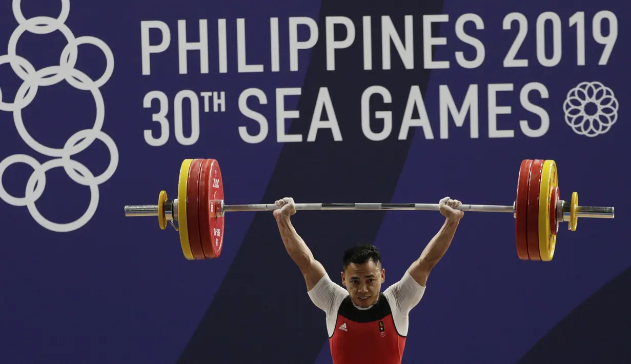 Lifter Eko Yuli melakukan angkatan saat SEA Games 2019 cabang angkat besi nomor 61 kg di Stadion Rizal Memorial, Manila, Minggu (1/12). Dirinya meraih emas dengan total angkatan 309 kg. (Bola.com/M Iqbal Ichsan)
