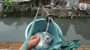 Tak sampai 5 menit, mie ayam ditambah teh dalam plastik pun sampai di tangan pembeli. Selanjutnya, uang pembayaran sebesar Rp 13.000 ribu ditaruh pada ember tersebut. Transaksi selesai saat penjual menarik kembali ember berisi uang. (merdeka.com/Arie Basuki)