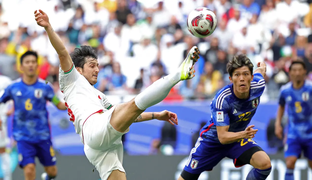 Pemain Iran, Sardar Azmoun menendang bola ke arah gawang Jepang pada laga perempat final Piala Asia 2023 di Education City Stadium, Al Rayyan, Sabtu (03/02/2024) WIB. (AFP/Giuseppe Cacace)